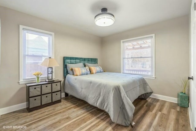 bedroom with multiple windows and hardwood / wood-style floors