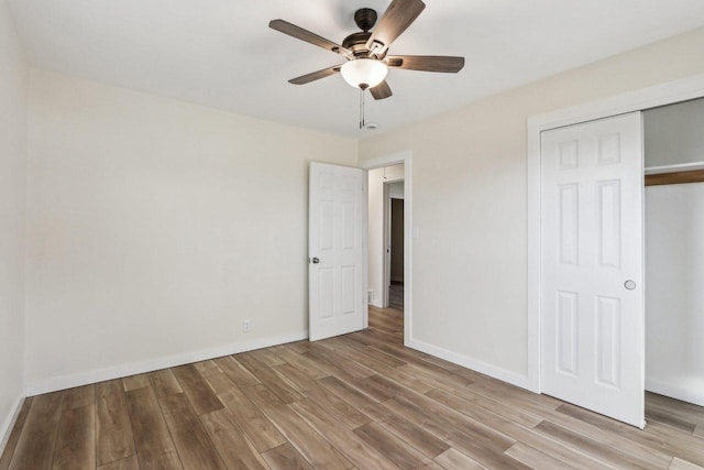 unfurnished bedroom featuring ceiling fan, light wood-type flooring, and a closet