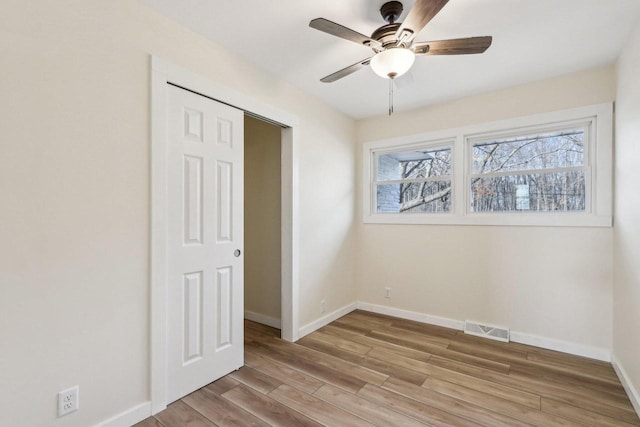 empty room with ceiling fan and light wood-type flooring