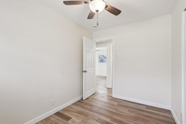 empty room with ceiling fan and light hardwood / wood-style floors