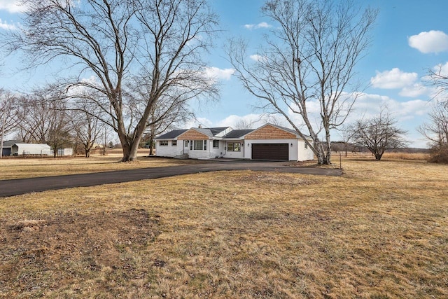 single story home featuring a garage and a front yard