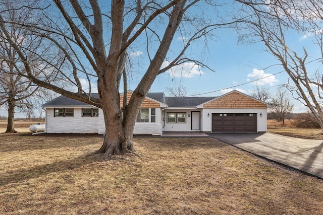 ranch-style house with a garage and a front lawn