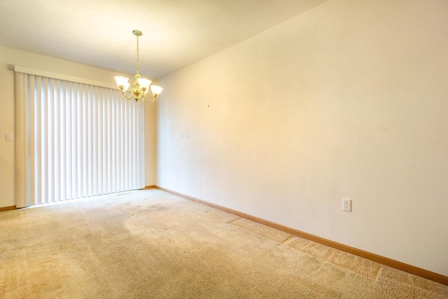 unfurnished room featuring a notable chandelier, baseboards, and light colored carpet