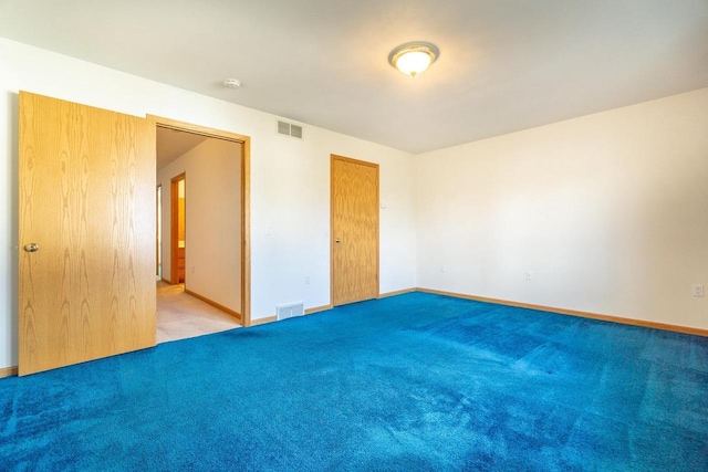 unfurnished bedroom featuring carpet floors, baseboards, and visible vents