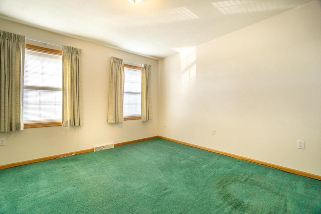 carpeted empty room with visible vents and baseboards