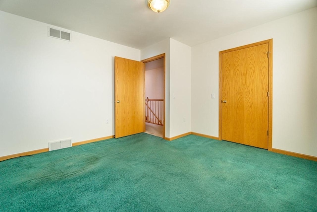 empty room featuring carpet flooring, visible vents, and baseboards