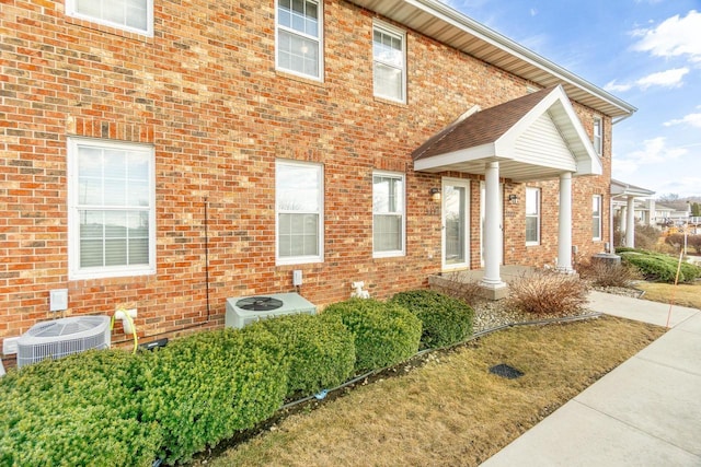 view of side of property featuring central AC unit and brick siding