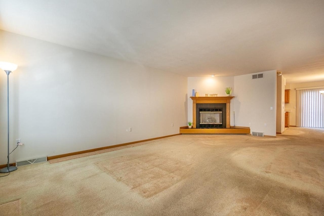 unfurnished living room with carpet floors, a tile fireplace, and visible vents