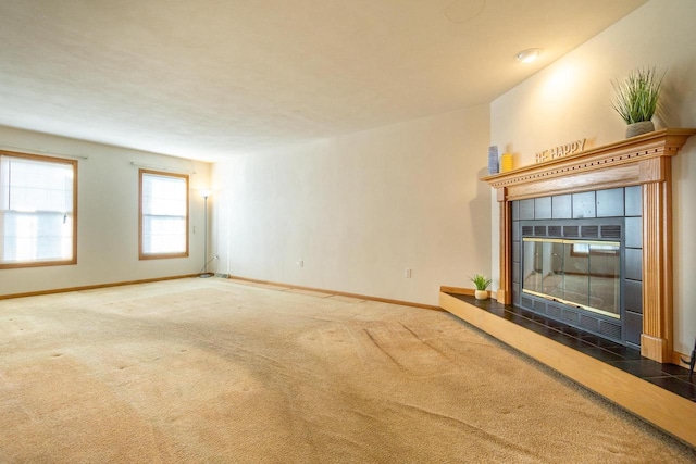 unfurnished living room featuring carpet, a fireplace, and baseboards