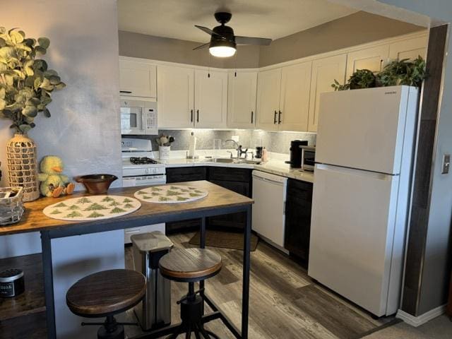 kitchen featuring white appliances, dark hardwood / wood-style floors, sink, and white cabinets