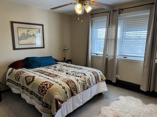 carpeted bedroom with multiple windows and ceiling fan