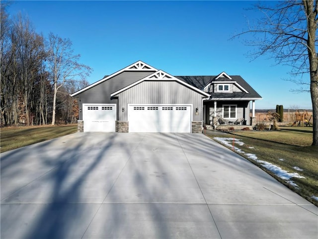 view of front of house featuring a porch, a garage, and a front yard