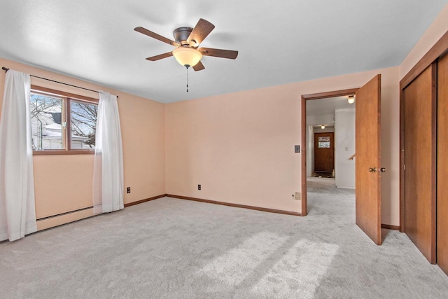 unfurnished bedroom featuring a baseboard heating unit, light colored carpet, a closet, and ceiling fan