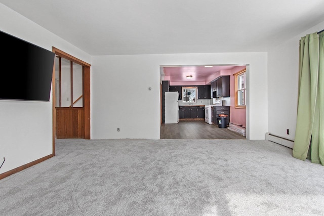 unfurnished living room featuring dark carpet and a baseboard radiator