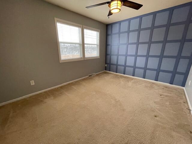 unfurnished room with carpet and ceiling fan