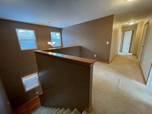 interior space featuring light carpet and an inviting chandelier