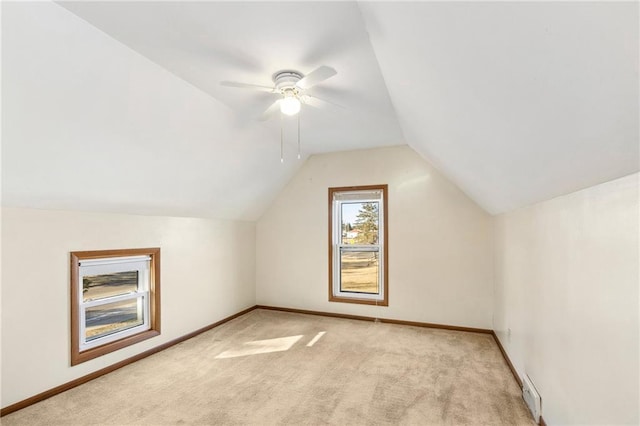 additional living space featuring lofted ceiling, light carpet, and ceiling fan