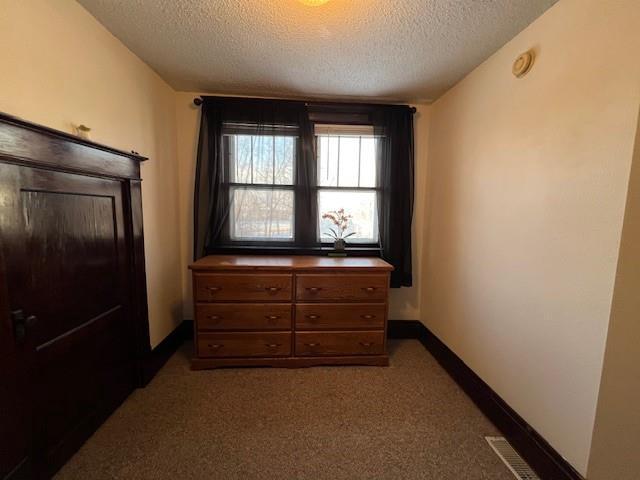 bedroom with carpet and a textured ceiling