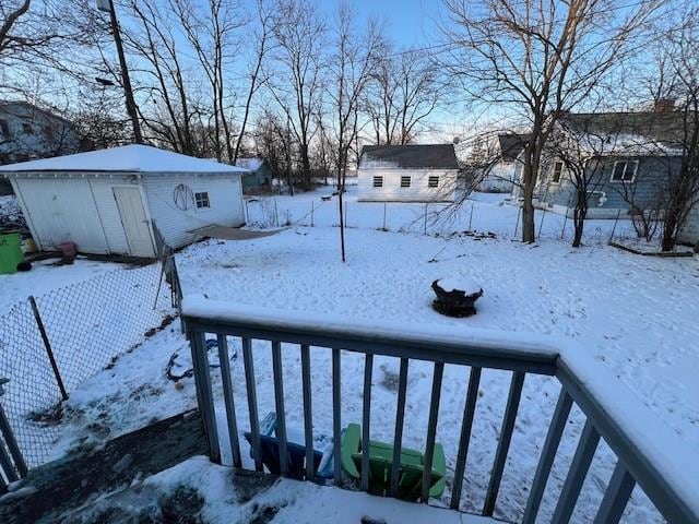 yard layered in snow with a storage unit