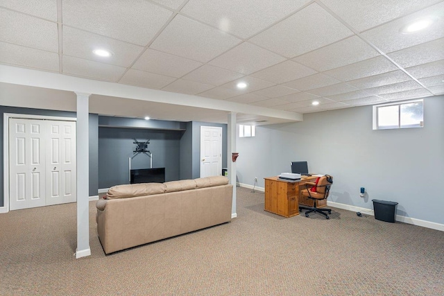 carpeted living room featuring a drop ceiling