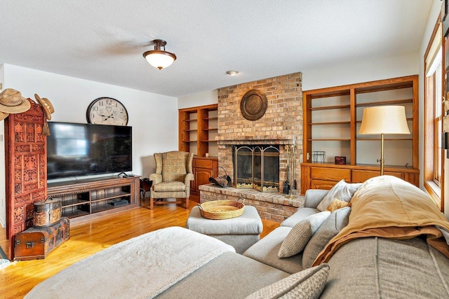 living room featuring a fireplace, hardwood / wood-style floors, and a textured ceiling