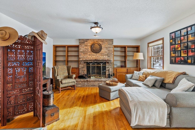 living room featuring hardwood / wood-style floors, a textured ceiling, and a fireplace