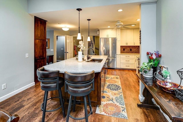2570 Roanoke Cir, Madison, WI 53719 - kitchen featuring freestanding refrigerator, a sink, white cabinets, a ceiling fan, and a kitchen island with sink