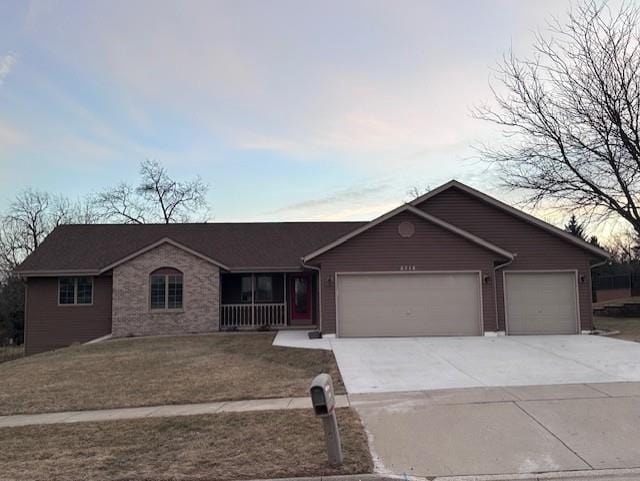 single story home featuring a yard and a garage