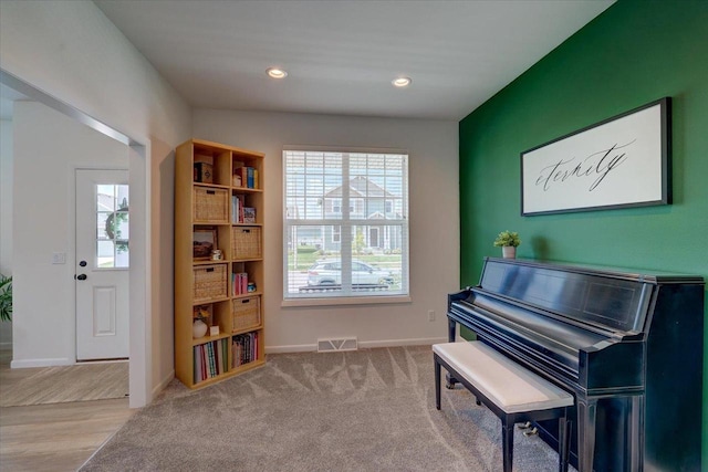 miscellaneous room featuring light colored carpet