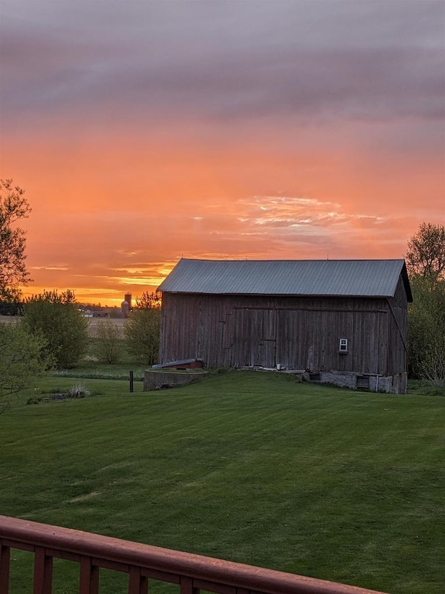 yard at dusk featuring an outdoor structure