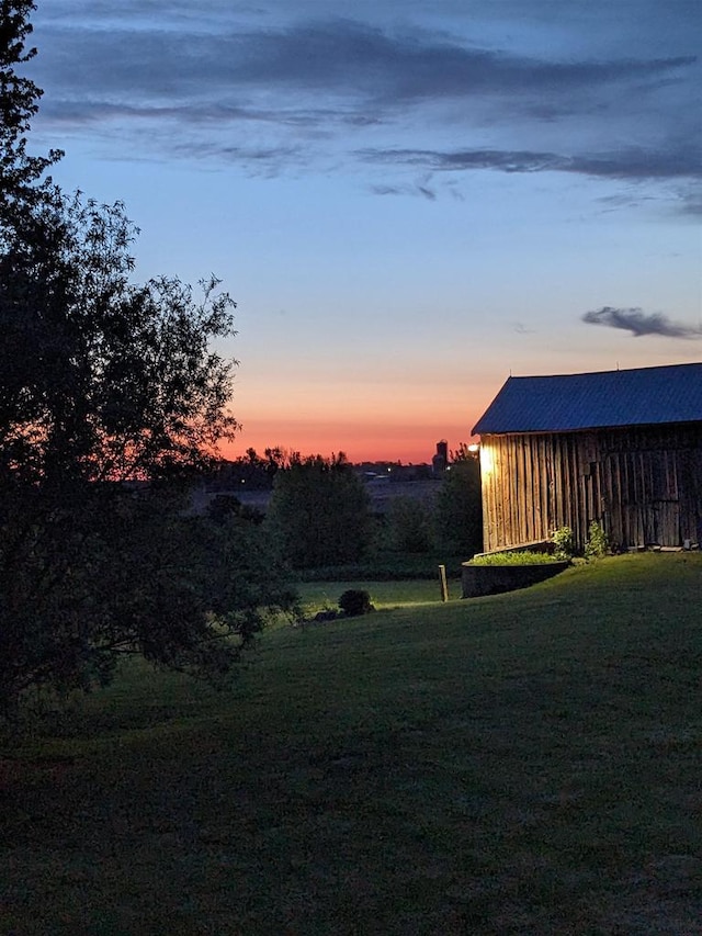 yard at dusk featuring an outbuilding