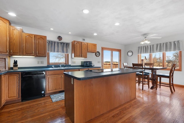 kitchen with a kitchen island, dark hardwood / wood-style floors, ceiling fan, and black appliances