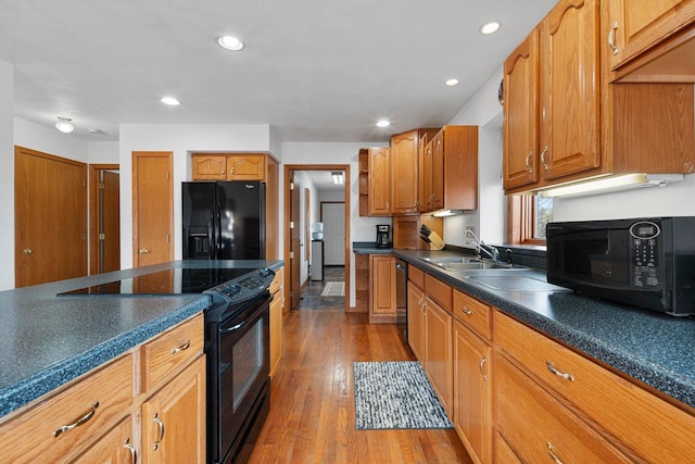 kitchen with hardwood / wood-style flooring, sink, and black appliances