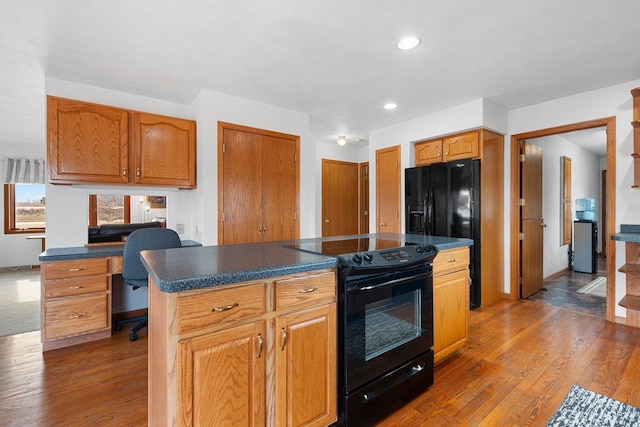 kitchen featuring wood-type flooring, black appliances, and a center island