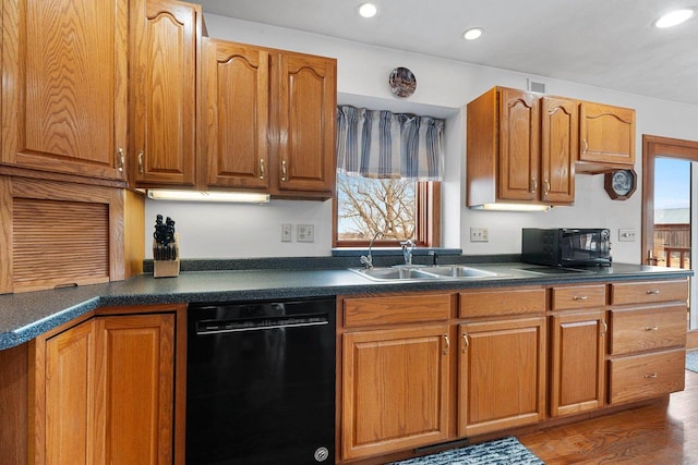 kitchen featuring sink, black appliances, and hardwood / wood-style floors