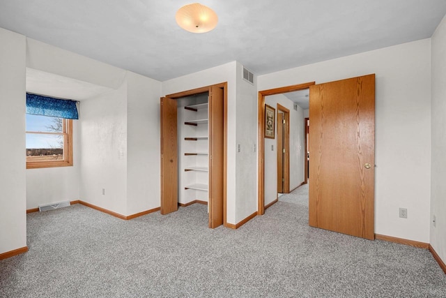 unfurnished bedroom with light colored carpet and a closet