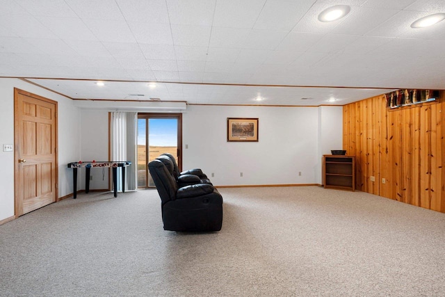 living area with wood walls and carpet flooring