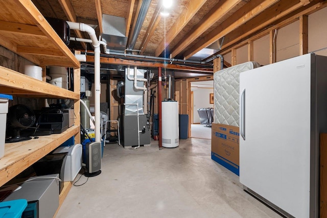 basement featuring white refrigerator, water heater, and heating unit