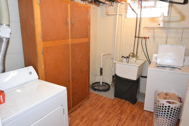 washroom with washer and clothes dryer, sink, and light hardwood / wood-style flooring