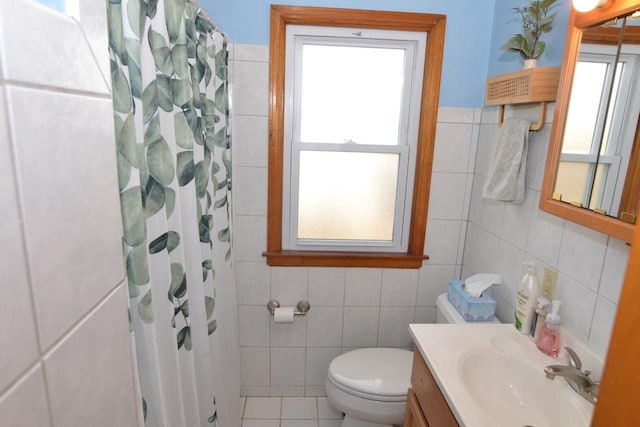 bathroom with tile walls, vanity, toilet, tile patterned floors, and a shower with curtain