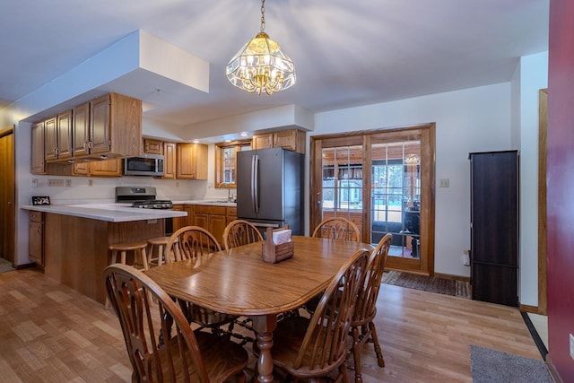 dining room featuring a notable chandelier, light hardwood / wood-style flooring, and sink