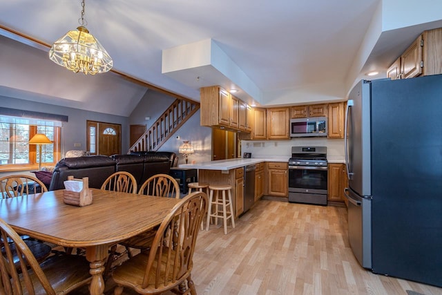 dining area with vaulted ceiling, light hardwood / wood-style floors, and a notable chandelier