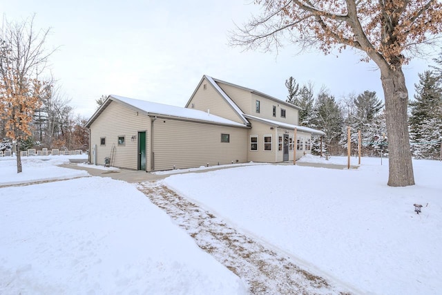 view of snow covered rear of property