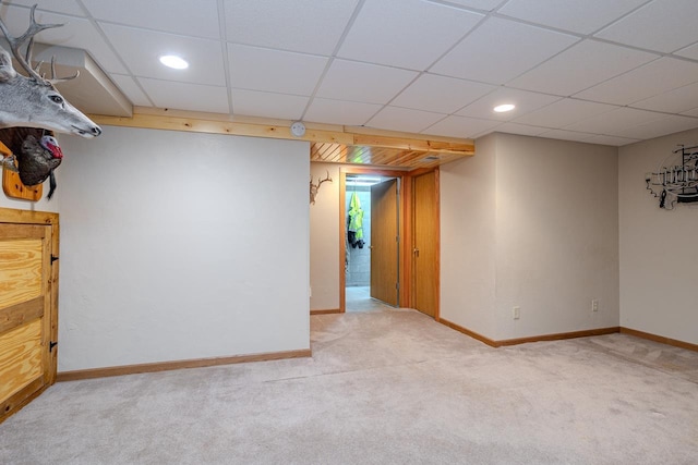 unfurnished room featuring light carpet and a drop ceiling