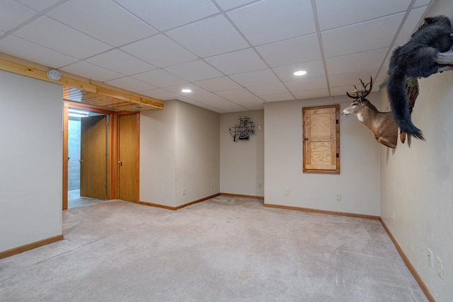 basement with light carpet and a paneled ceiling