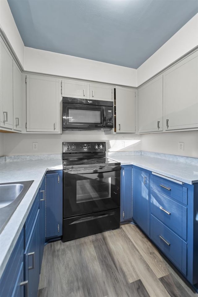 kitchen featuring blue cabinets, hardwood / wood-style flooring, and black appliances