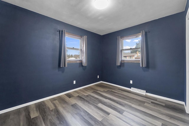 spare room featuring hardwood / wood-style floors and a healthy amount of sunlight