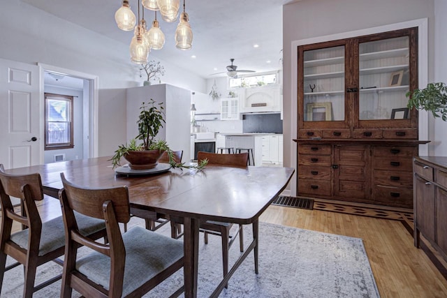 dining area with ceiling fan and light wood-type flooring