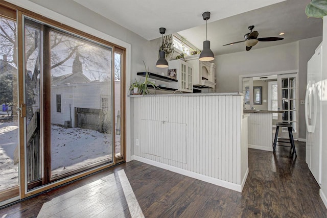 kitchen with pendant lighting, a fireplace, white cabinetry, white refrigerator, and dark wood-type flooring