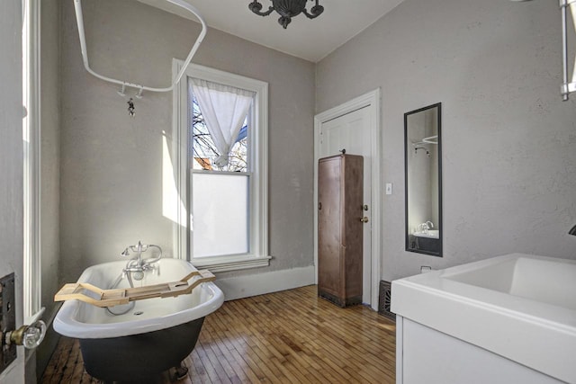 bathroom with wood-type flooring, sink, and a bathtub